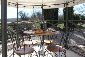 贝尔格新城Chambres d'hôtes Des couleurs et des Mots的露台上遮阳伞下的桌子和椅子