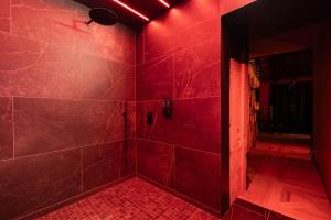 a red bathroom with a shower with red lighting at loveroom le donjon in Anse