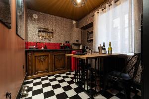 a kitchen with a table and a checkered floor at loveroom le donjon in Anse