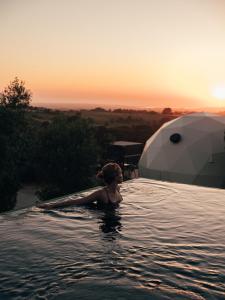a woman standing in the water in a swimming pool at wecamp Reserva Alecrim in Santiago do Cacém
