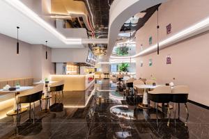a restaurant with tables and chairs in a room at Jin Yi X Hotel in Hekou