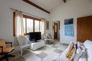 巴拉尤娜Casa Alto Padrao com 5 Suites e Jacuzzi Privativa的客厅里有一张沙发和一台电视