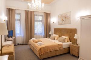a bedroom with a large bed and a chandelier at LD Morava in Karlovy Vary +41 photos