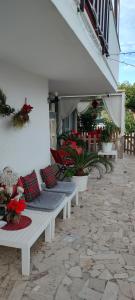 a row of white benches sitting outside of a building at Casa dei sospiri in Polignano a Mare