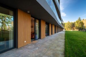 eine Außenansicht eines Gebäudes mit einem Grasfeld in der Unterkunft Vidok Apartamenty, Sun & Snow in Olsztyn