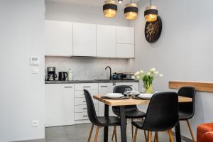 eine Küche und ein Esszimmer mit Tisch und Stühlen in der Unterkunft Vidok Apartamenty, Sun & Snow in Olsztyn