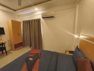 a room with a couch and a desk and a television at Apex Inn Manyata in Bangalore