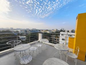 a balcony with tables and chairs on a building at Apex Inn Manyata in Bangalore