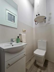 a white bathroom with a sink and a toilet at Apartalux Villa Playa in Benidorm