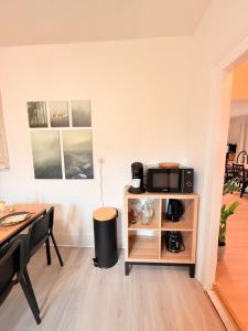 a living room with a table and a tv on a shelf at Colmar St Joseph Nature Cocoon in Colmar
