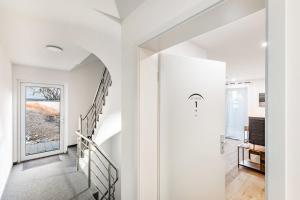 a hallway with white walls and a staircase with a door at Global Bnb - Ay Homes in Friedberg