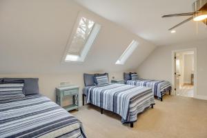 a attic bedroom with two beds and two windows at 2 Mi to Tims Ford Lake! Cozy Cottage with Fireplace in Winchester