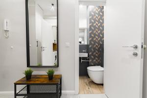 Un baño con inodoro, lavabo y espejo. en Apartament w Centrum Warszawy - Dworzec Centralny, en Varsovia 11 fotos más