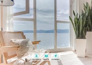 a room with a chair and a large window at Blue Ocean Deluxe in Portonovo