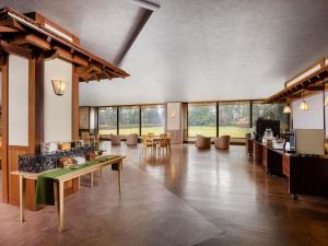 砺波市Mercure Toyama Tonami Resort & Spa的一间有桌椅和窗户的大房间