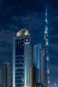 Un edificio alto con un cartel en una ciudad. en Millennium Central Downtown - Dubai, en Dubái