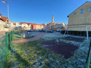 a child is standing in a park with a playground at MIESZKANIE APRTEMNT DO WYNAJECIA na doby Bolesławiec in Bolesławiec