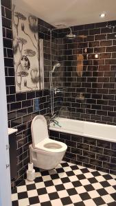 une salle de bain avec toilettes et un sol à carreaux noirs et blancs dans l'établissement Park Crescent Brighton, à Brighton et Hove 3 autres photos