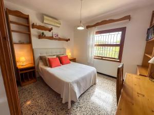 una camera da letto con un letto con cuscini rossi e una finestra di Vinya del mar a Deià