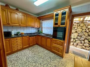 una cucina con mobili in legno e un muro in pietra di Vinya del mar a Deià Altre 29 foto