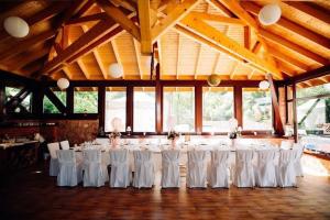 红湖Lacu Roșu Mountain Lodge的大楼内一间设有白色桌椅的房间