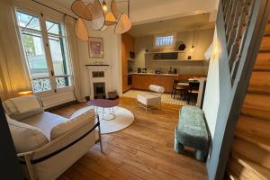 een woonkamer met een bank en een tafel bij Maison Gabrielle - Welkeys in Charenton-le-Pont