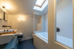 een badkamer met een douche, een bad en een wastafel bij Maison Gabrielle - Welkeys in Charenton-le-Pont +4 foto's