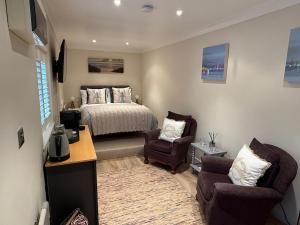 a bedroom with a bed and a desk and two chairs at Coastal Escape in Hamworthy