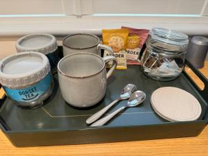 a tray with cups and spoons on a table at Coastal Escape in Hamworthy