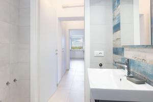 a white bathroom with a sink and a mirror at Il Cavo Suites - Elba Affitti in Cavo