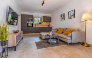 ein Wohnzimmer mit Sofa und Tisch in der Unterkunft Cozy holiday home Ella Nature with pool near the beach in Peroj