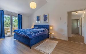 ein Schlafzimmer mit einem blauen Bett und einem Fenster in der Unterkunft Cozy holiday home Ella Nature with pool near the beach in Peroj + 24 Fotos