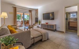 ein Wohnzimmer mit Sofa und Fernseher in der Unterkunft Cozy holiday home Ella Nature with pool near the beach in Peroj