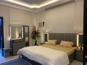 a bedroom with a large bed and a mirror at عين دبي للشقق المفروشة-عائلات in Taif