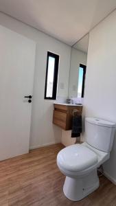a bathroom with a white toilet and a sink at Complejo Nomade Home in Marcos Juárez +6 photos