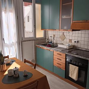 una cucina con armadi blu e un tavolo con tazze di Accogliente e comoda Casa Rampa a Campobasso