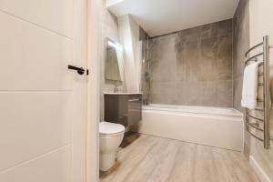 a bathroom with a toilet and a tub and a sink at Elysée Suites - Lovely 2 Bed Flat in Southport in Southport