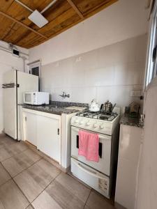 een keuken met een fornuis met een roze handdoek erop bij Departamentito Cabral in Tandil