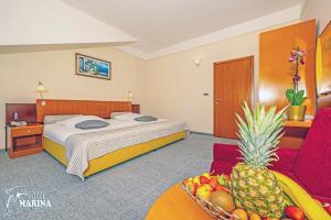 ein Hotelzimmer mit einem Bett und einer Obstschale in der Unterkunft Hotel Marina in Selce + 48 Fotos