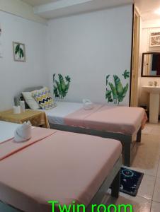 Habitación con 2 camas y 2 mesas en Lola Flor's Guest House, en El Nido