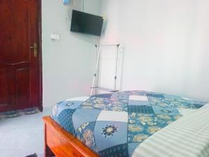 a bedroom with a bed with a quilt on it at Haven Guest House in Kasese