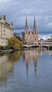 eine Brücke über einen Fluss in einer Stadt mit Gebäuden in der Unterkunft Hôtel Le Rohan, centre Cathédrale in Straßburg