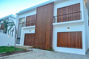 a house with wooden garage doors on it at Casa Marah - Trancoso in Trancoso