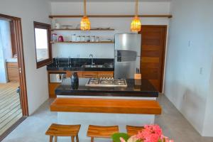 a kitchen with a stove and a refrigerator at Casa Marah - Trancoso in Trancoso
