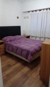 a purple bed in a room with a wooden floor at Casa Chauvin con pileta in Mar del Plata
