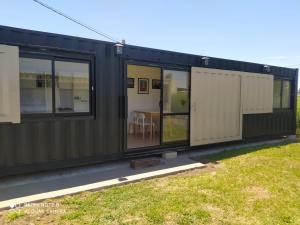 a black house with large windows and a yard at Complejo Nomade Home in Marcos Juárez