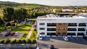 Una vista aérea de un estacionamiento más grande frente a un edificio. en River Park Hotel, en Drăgăşani