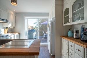 a kitchen with white cabinets and a counter top at Lakeside & Private dock - Le Suisse d-Entrelacs in Entrelacs