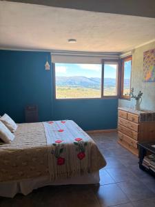 a bedroom with a bed and a large window at Cabaña Esquina Siracusa in Villa Yacanto +33 photos