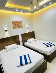 two beds in a room with blue and white towels at Amer Group Villas and Chalets on the Pool in Ain Sokhna